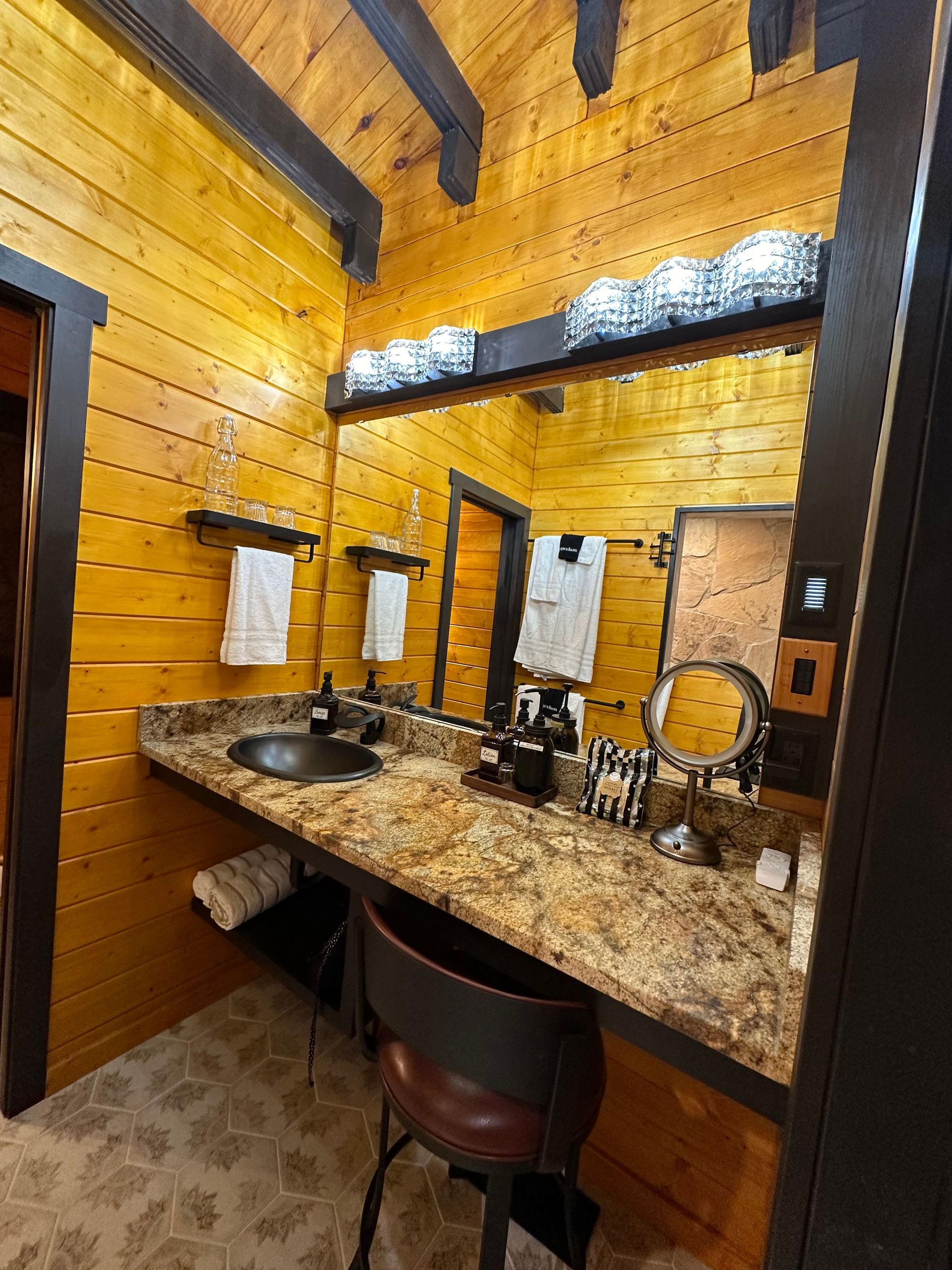 A bathroom with two sinks , a mirror and a chair.