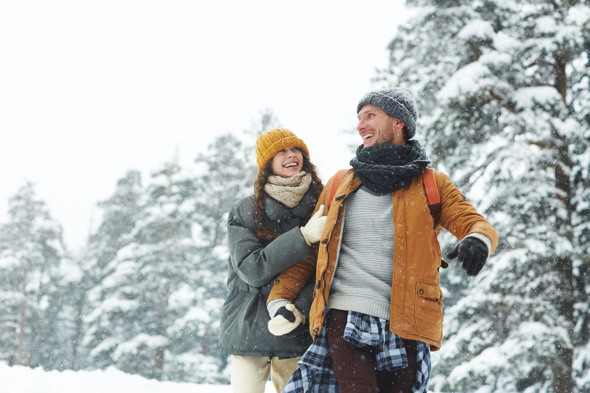 A man and a woman are hiking in the woods.