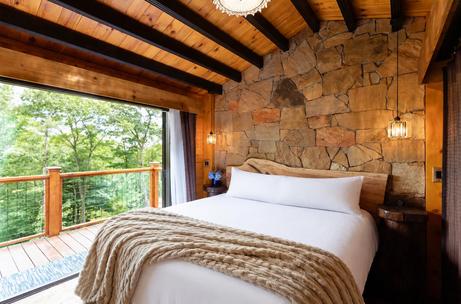 An empty room with a wooden floor and a stone wall