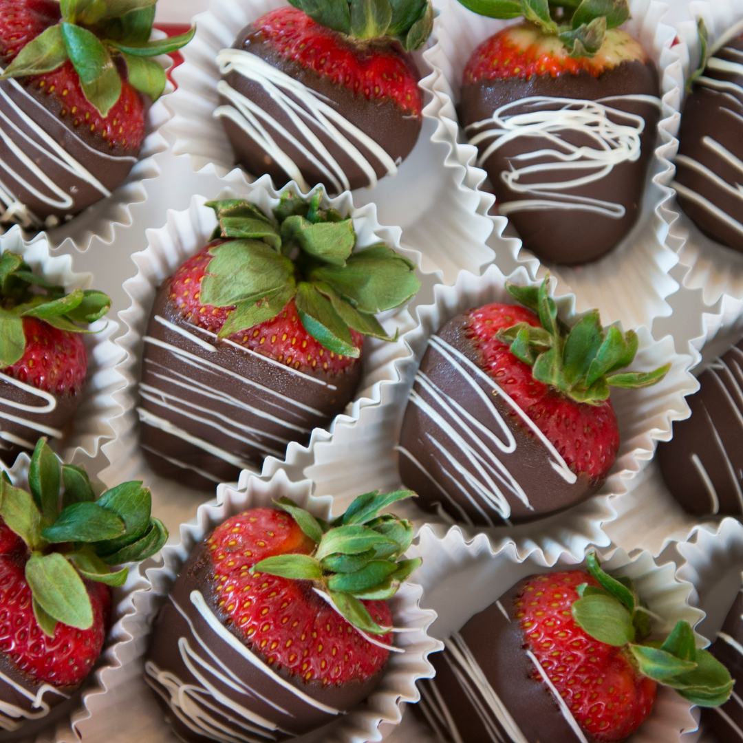 A bunch of chocolate covered strawberries in wrappers