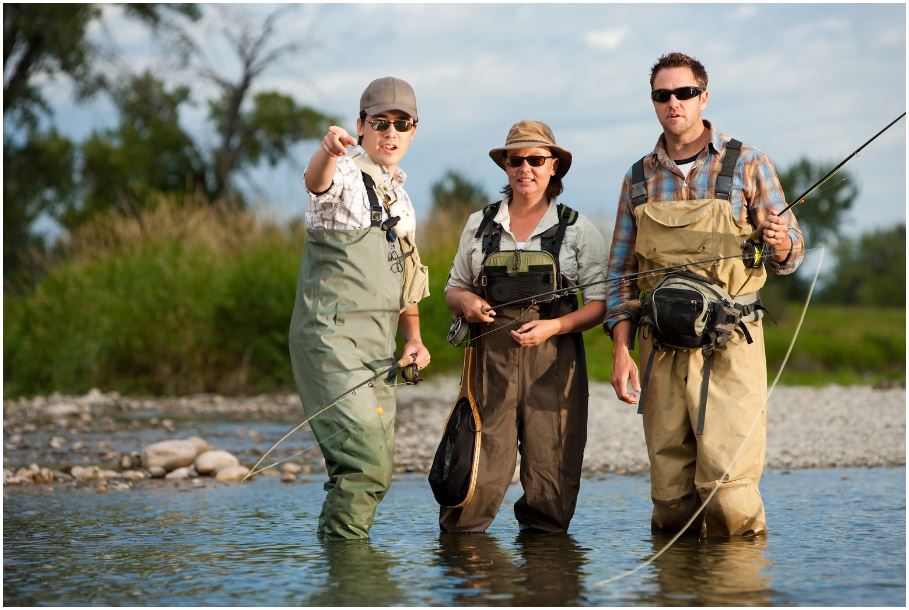 two men and a woman are fishing in a river