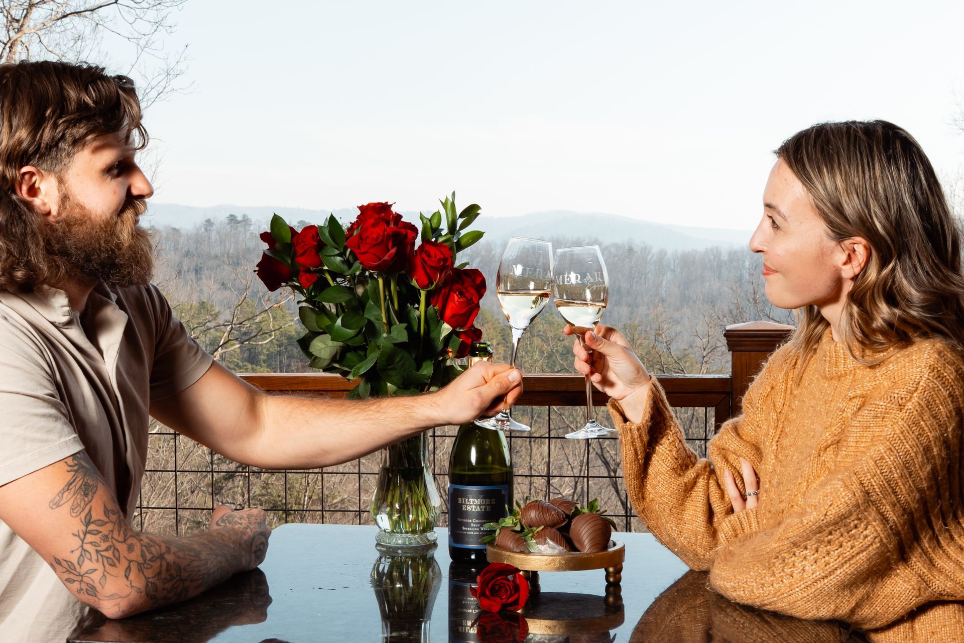 A man and a woman are sitting in a hot tub holding wine glasses.