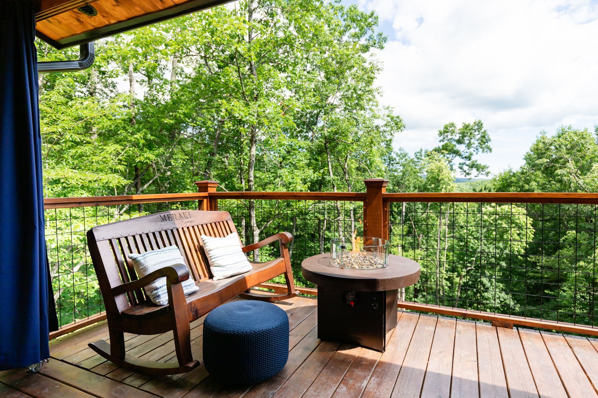 A wooden deck with a hot tub and a fire pit.