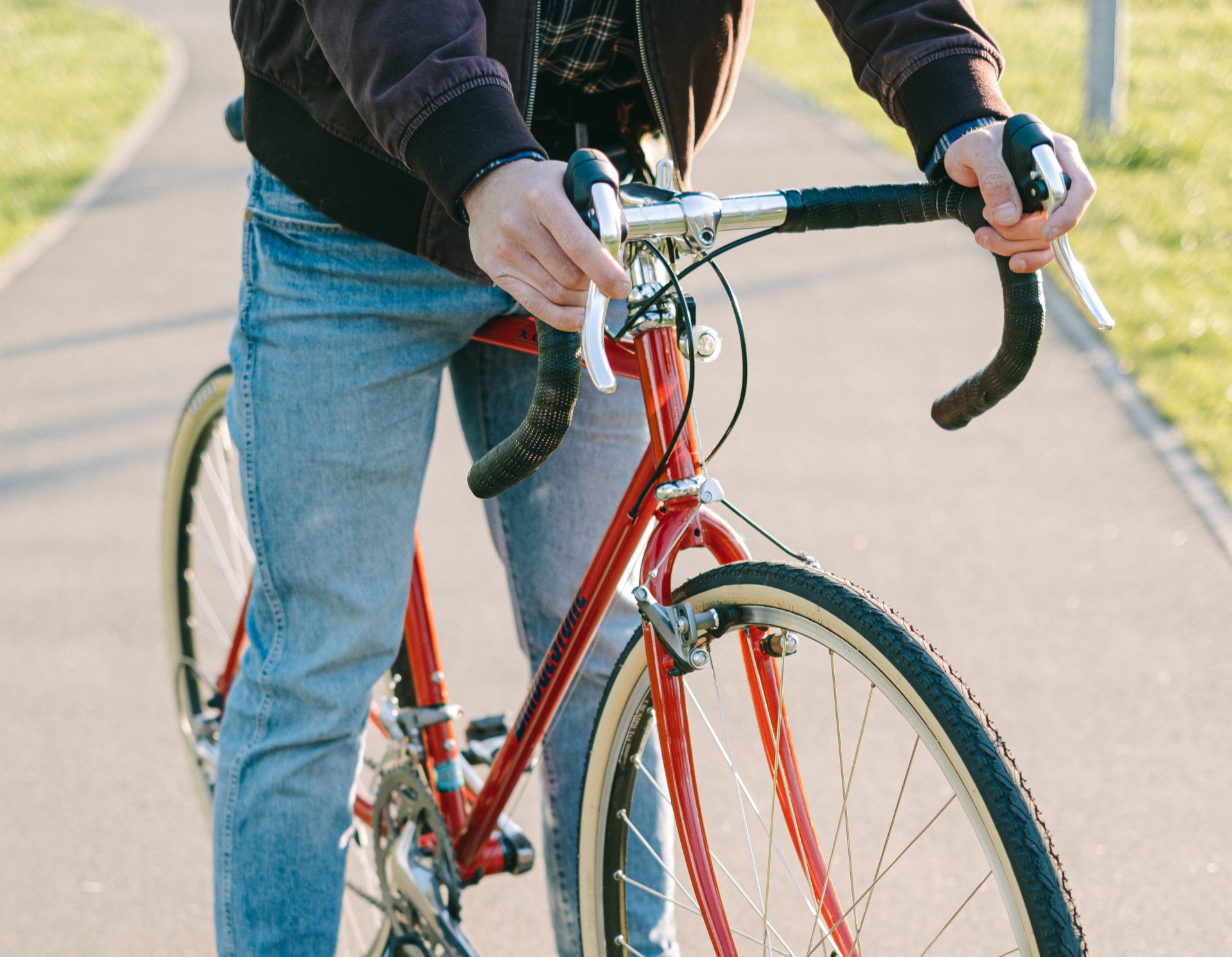 a man is riding a red bicycle on a path .