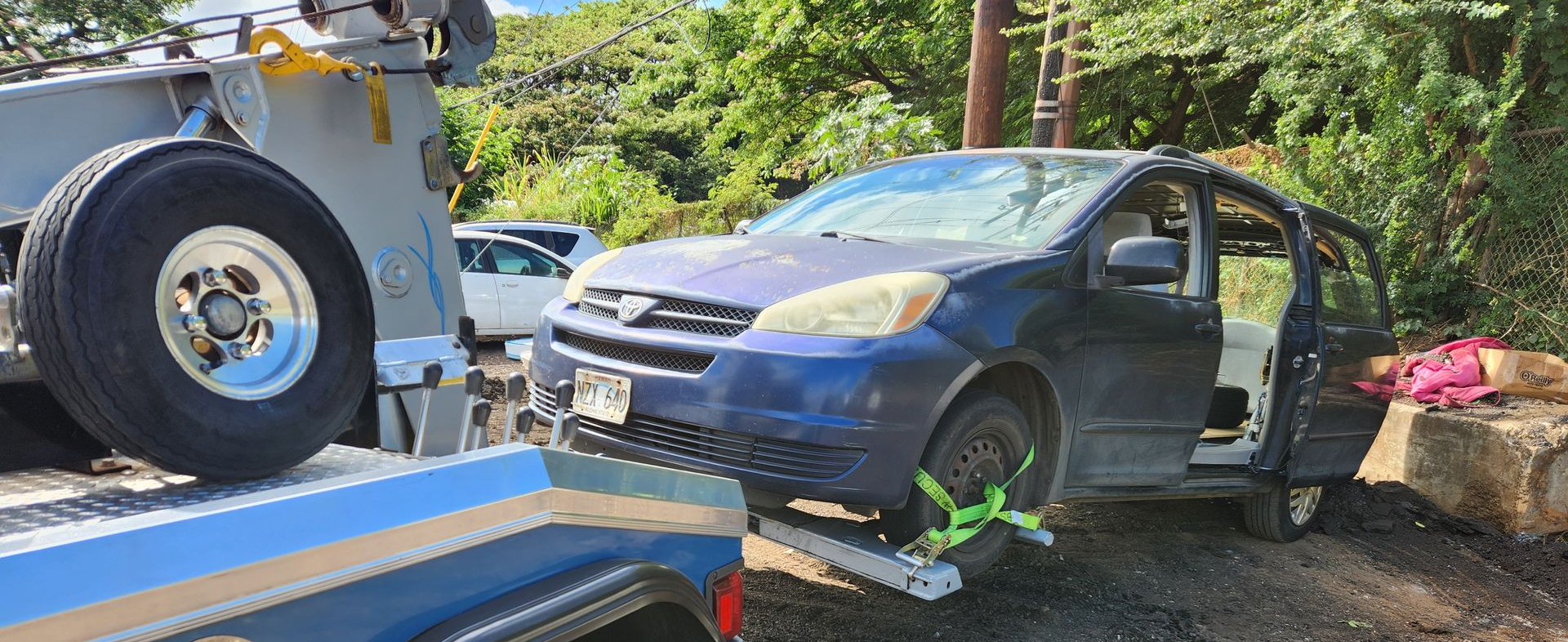 White tow truck hauling a blue van