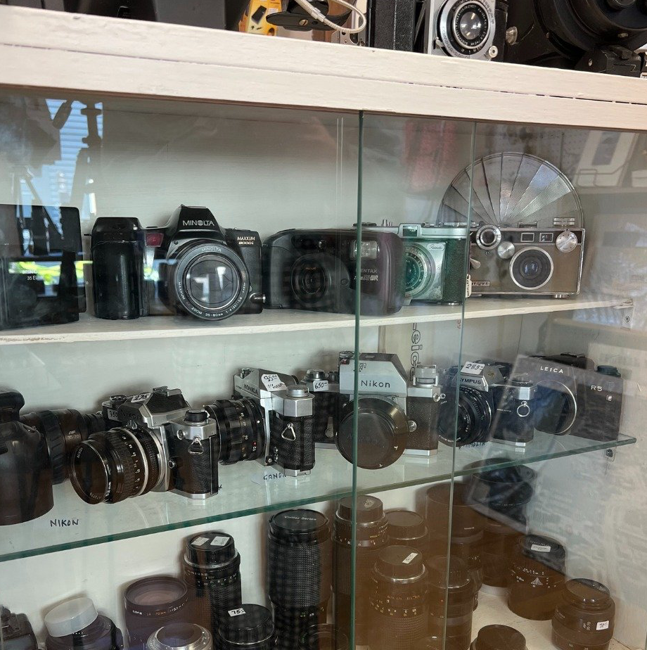 A display case filled with cameras and lenses