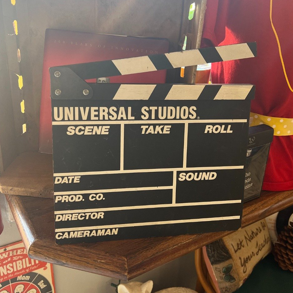 A clapper board from universal studios sits on a shelf