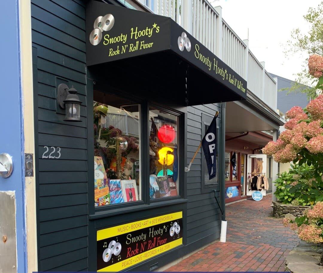 A store front with a black awning that says sweety hooky 's