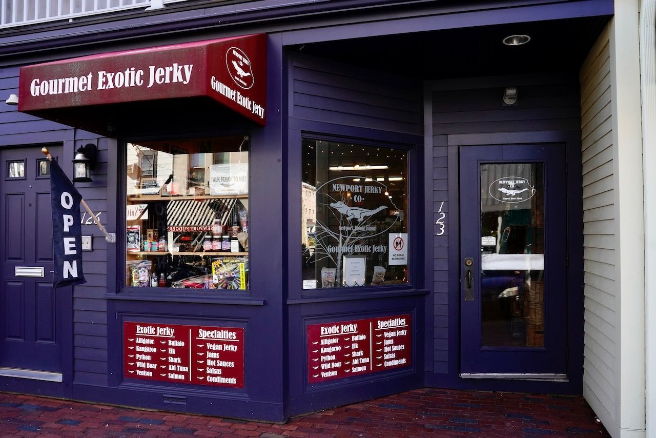 A purple building with a red awning that says gourmet exotic jerky