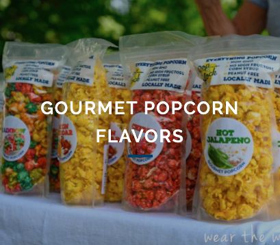 Several bags of gourmet popcorn are lined up on a table