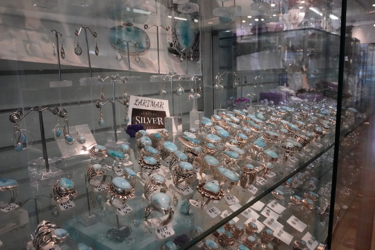 A display case filled with lots of turquoise and silver jewelry.