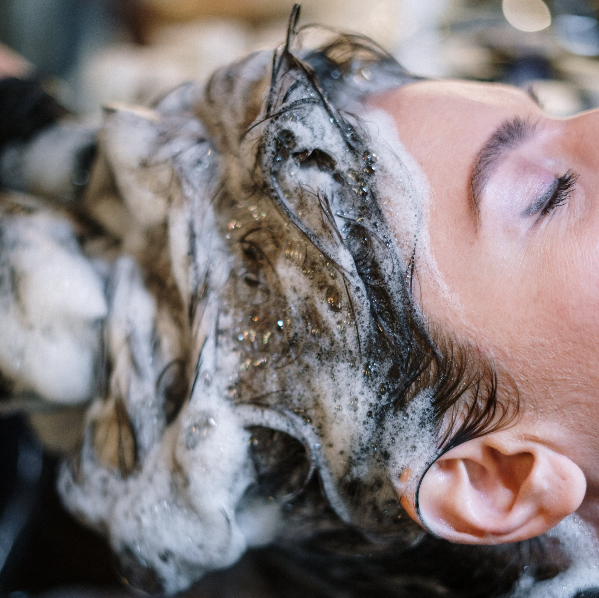 A woman is getting her hair washed in a salon.