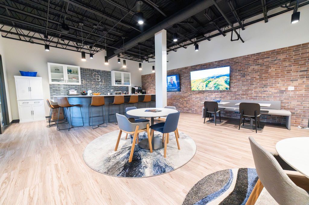 Photo of a kitchen and lounge area with brick wall and work stations