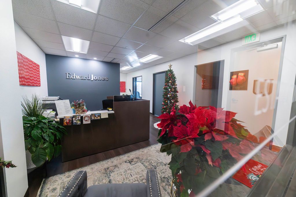 Reception area with a desk, poinsettias, and a Christmas tree; office setting.