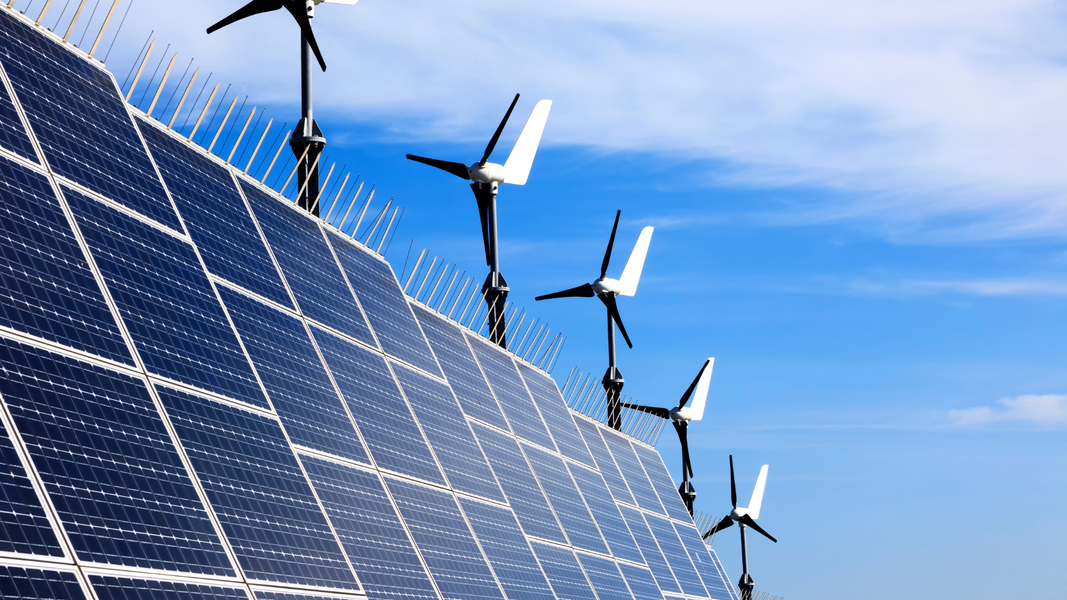 Solar panels on a residential roof, absorbing sunlight. White house with red tile roof and blue sky.