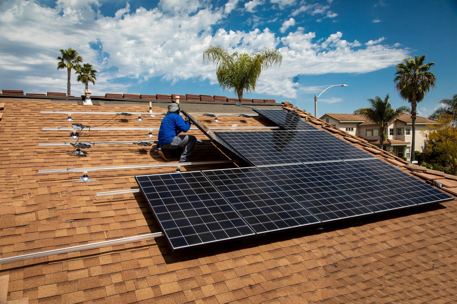 a man is installing solar panels on the roof of a house