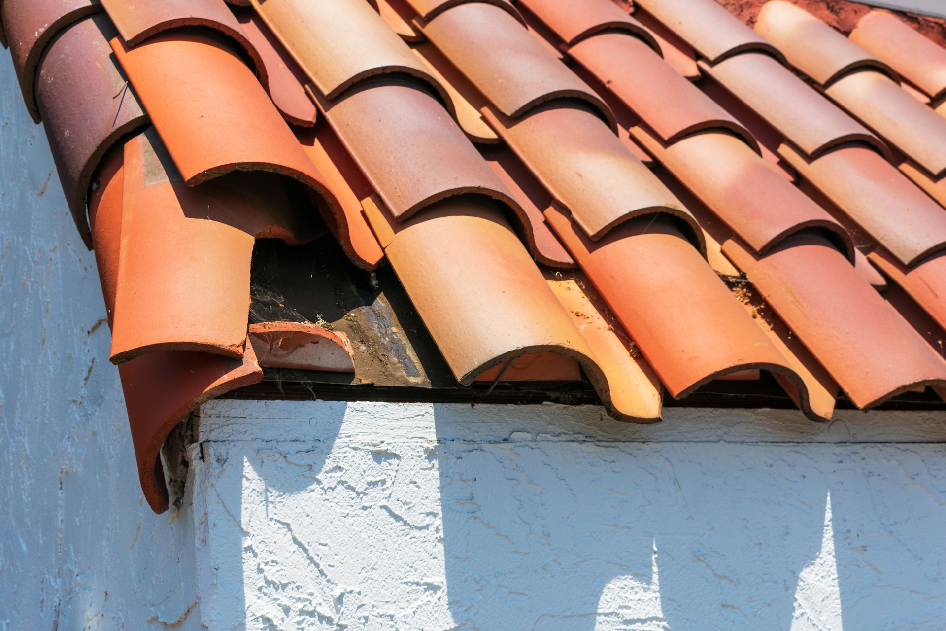 a close up of a roof with a white wall in the background