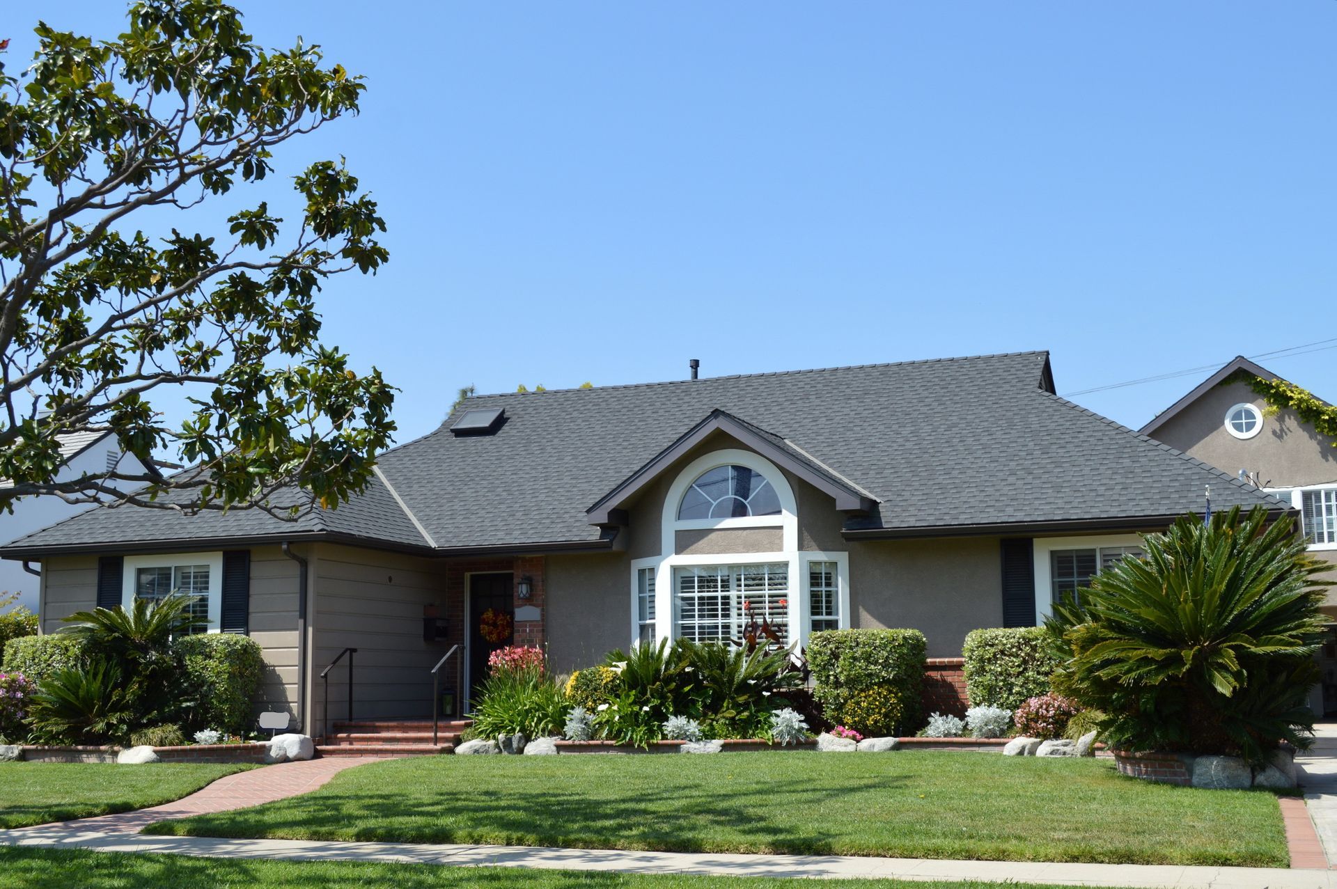 a house with a gray roof and a large window