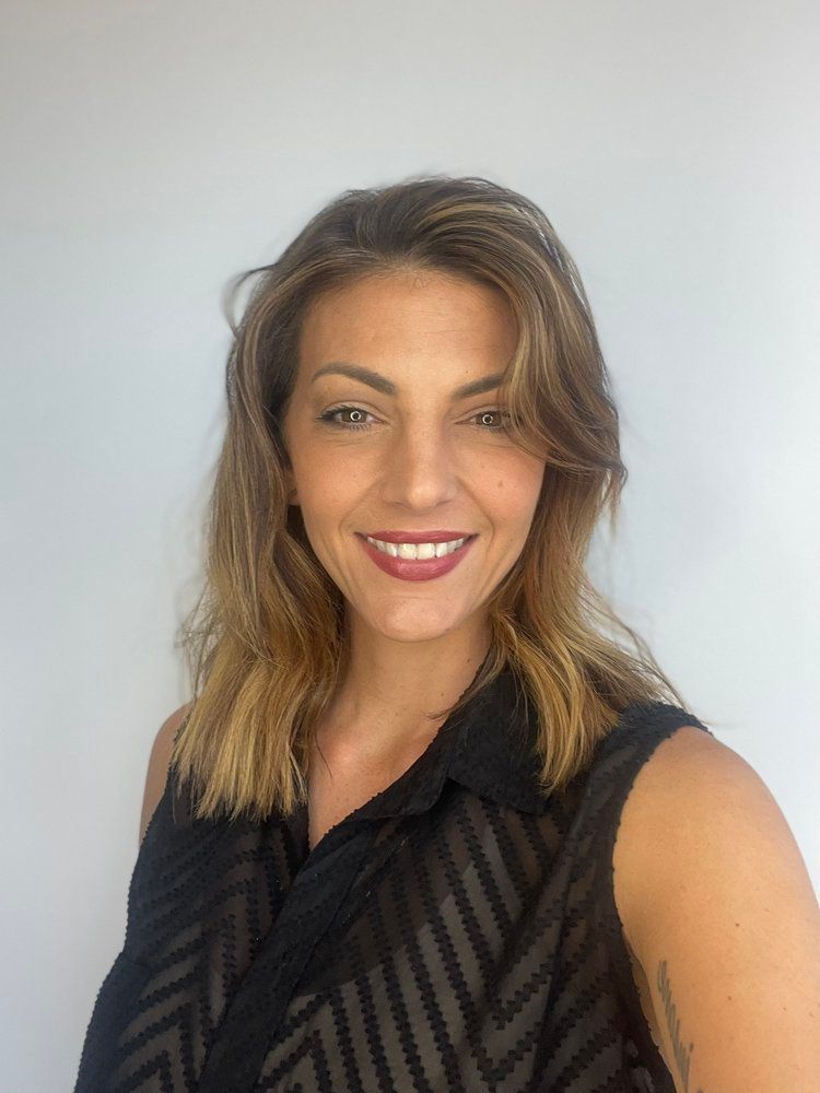 A woman in a black shirt is smiling for the camera.