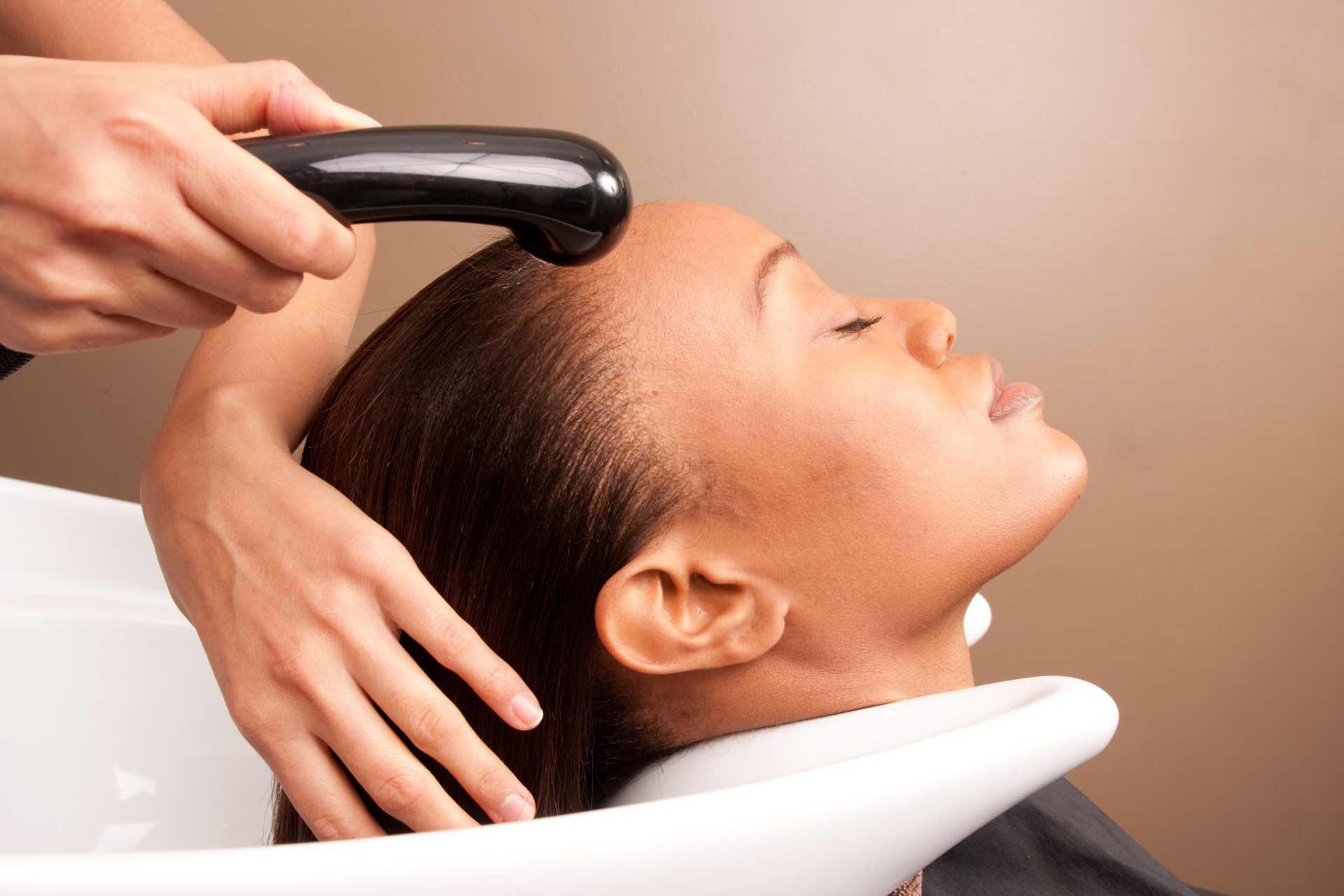 Hair Treatment —  Young Woman Examining Herself In The Mirror in Temple Hills, MD