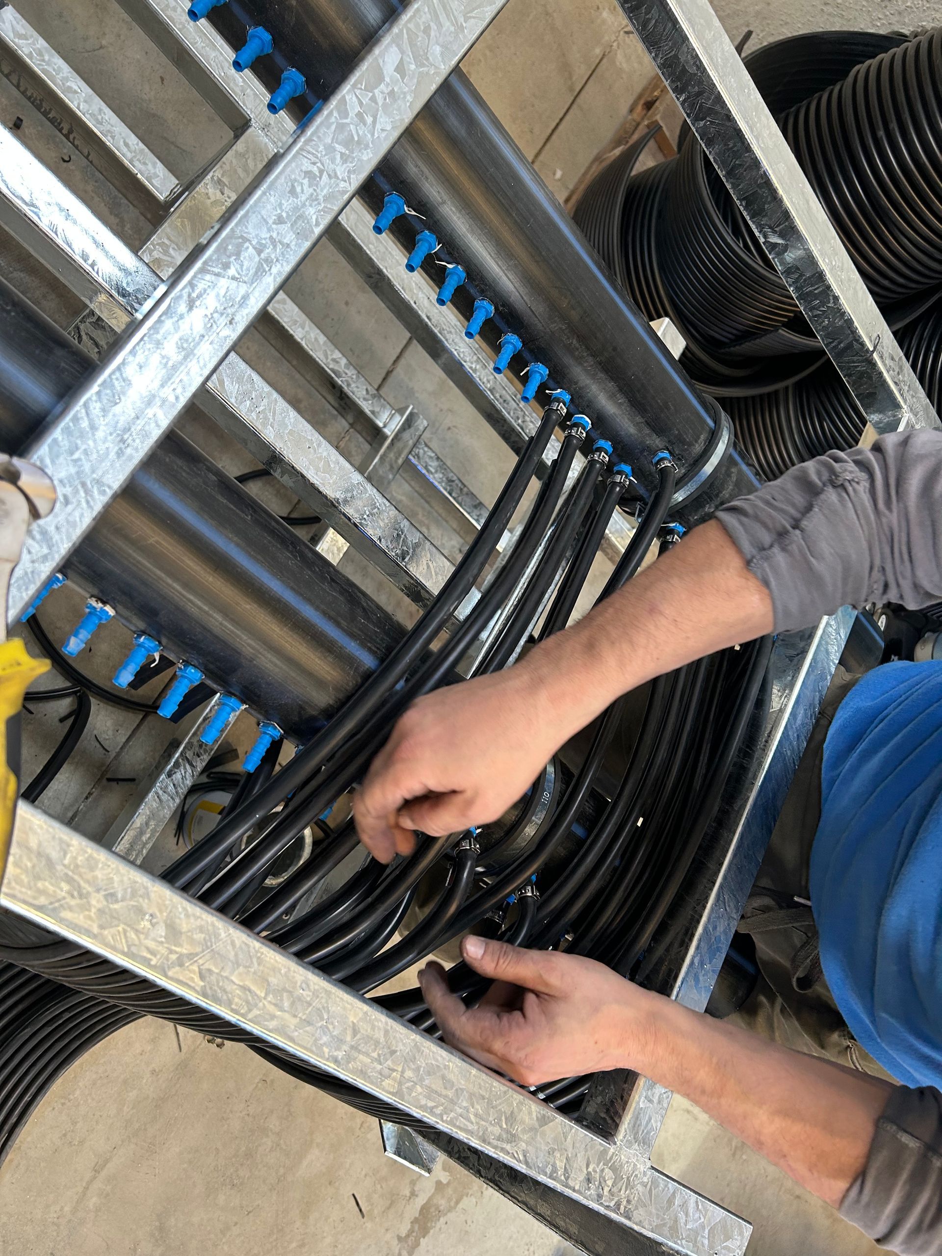 Un hombre está trabajando con un montón de cables en una jaula de metal.