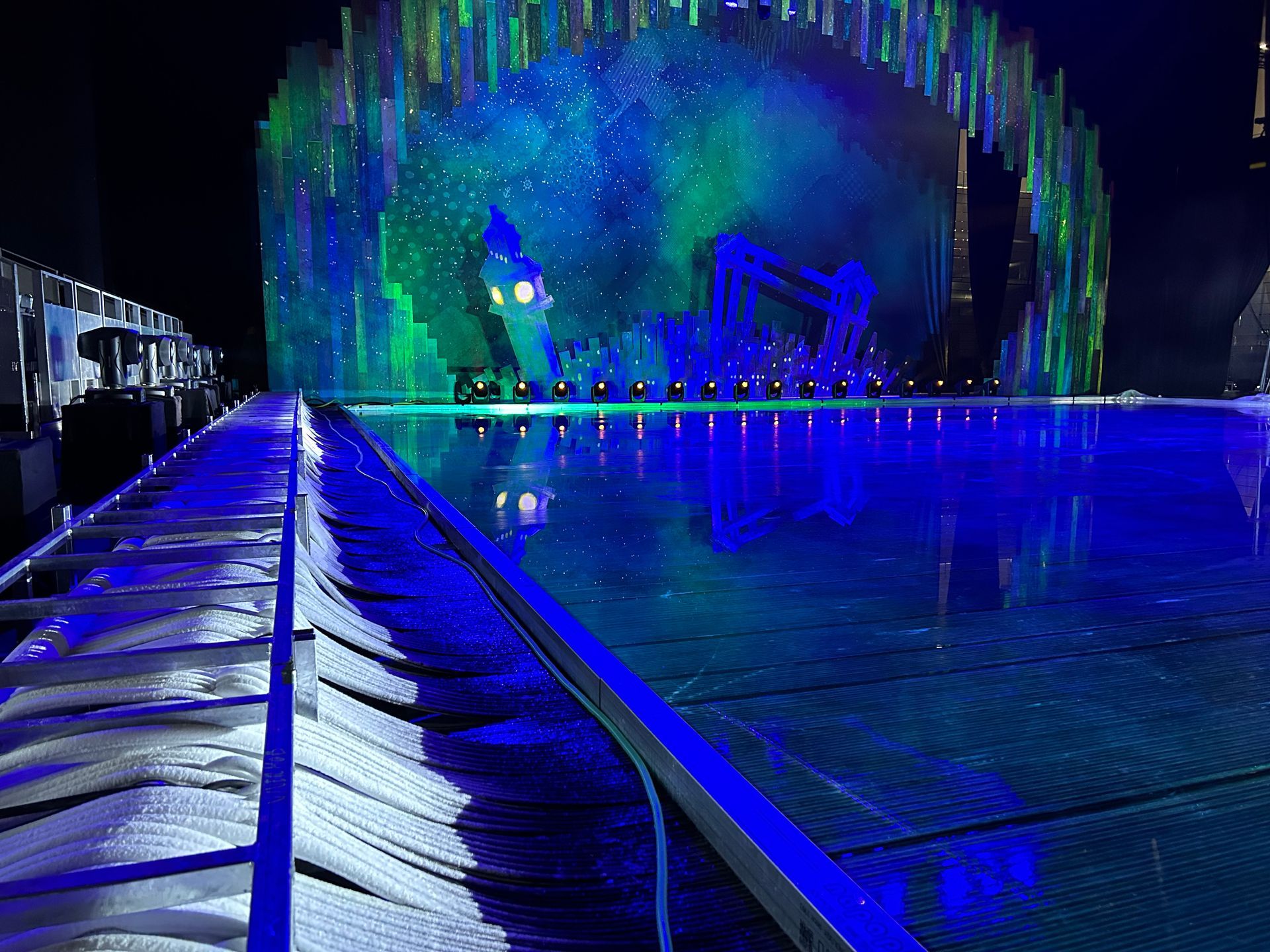 Una gran piscina está iluminada con luces azules por la noche.