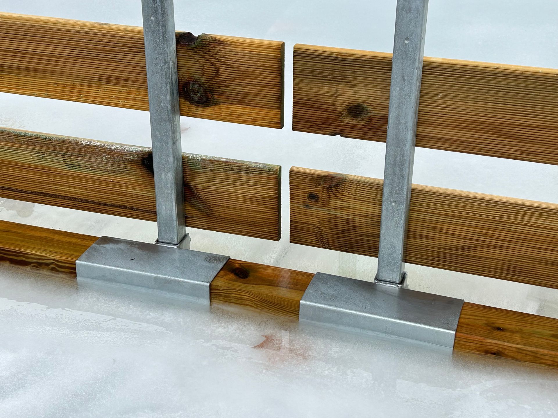 Anclaje de los soportes de una valla de madera en una pista de hielo temporal