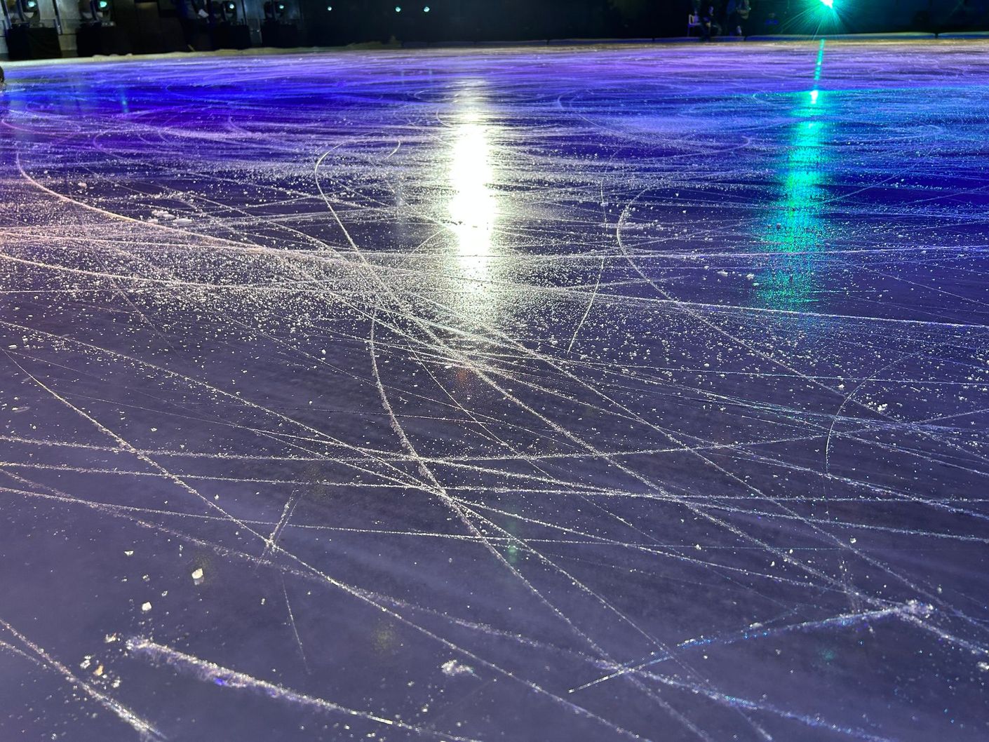 Un primer plano de una pista de hielo violeta por la noche.