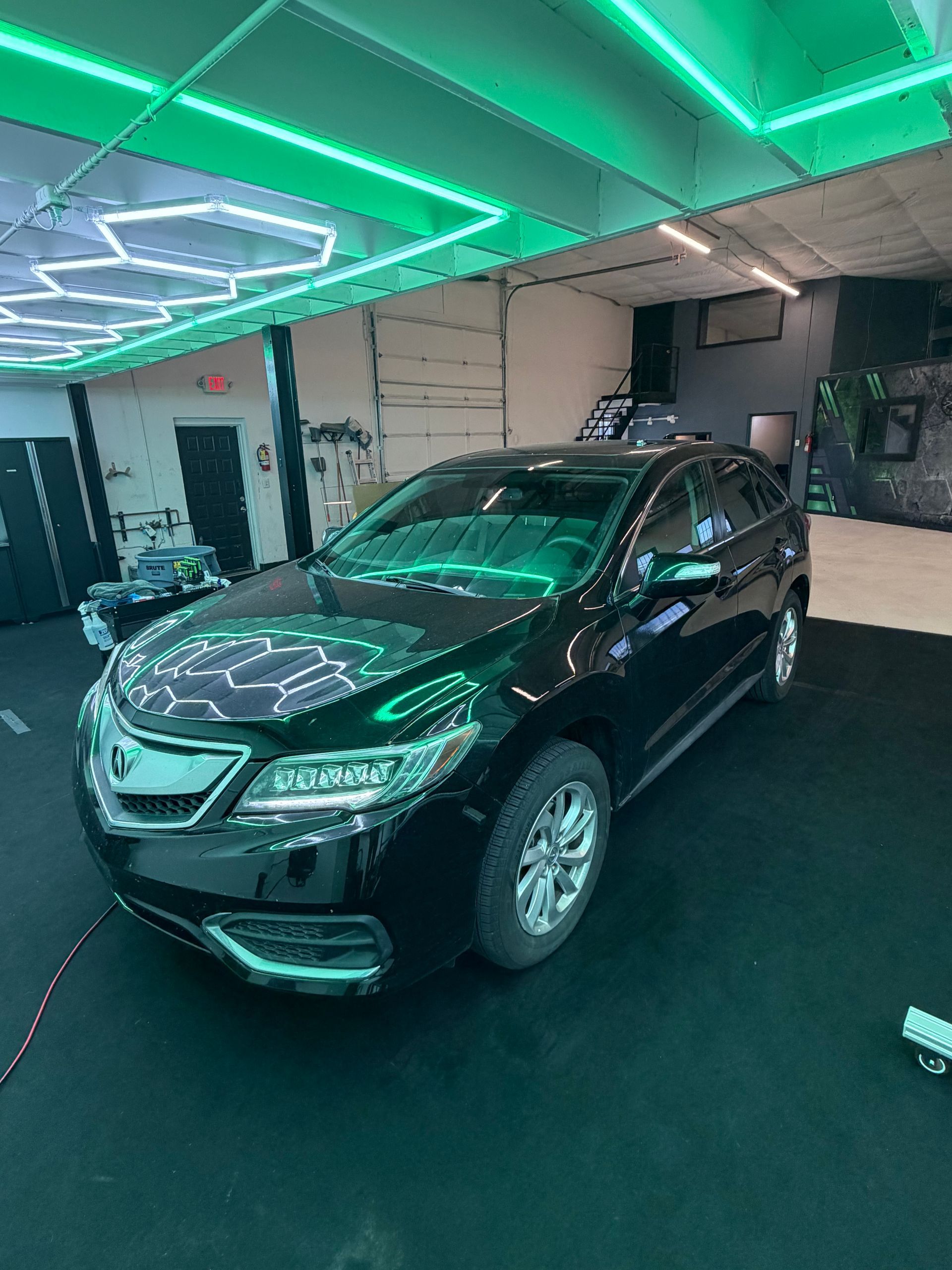 Black SUV in a showroom under green neon lighting