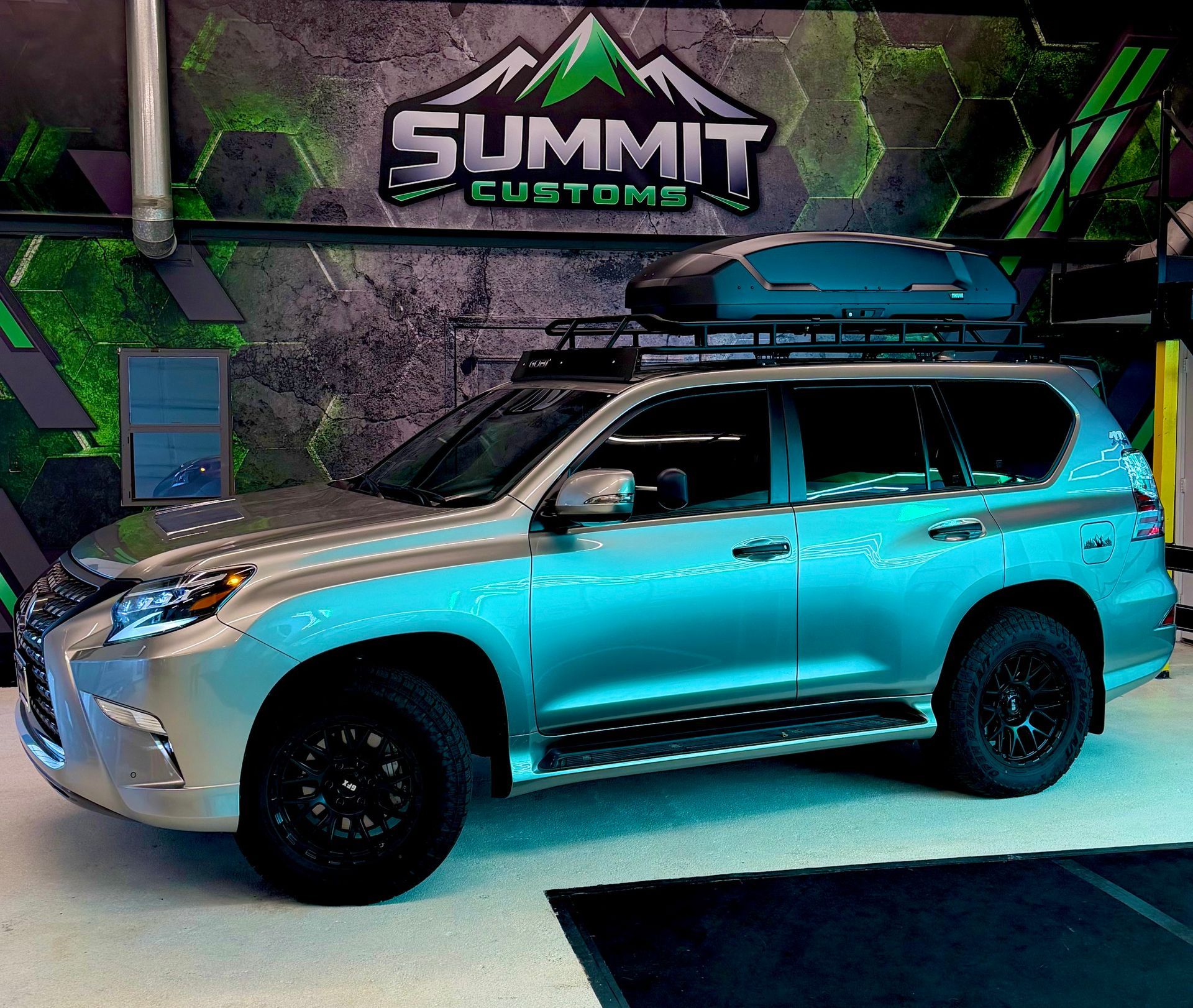 White SUV parked in a garage under green neon lights
