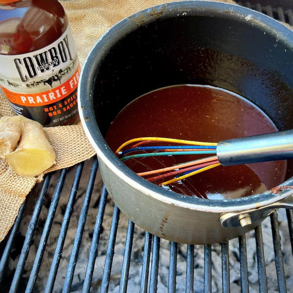 Cowboy Korean BBQ Sauce in a saucepan with bottle of Cowboy Prairie Fire BBQ Sauce