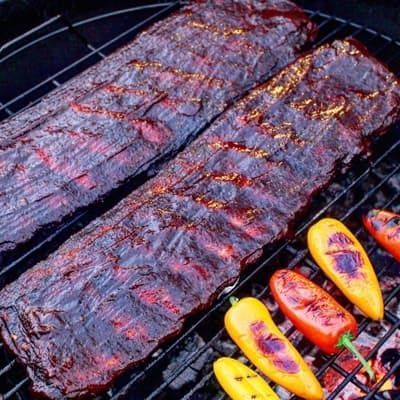 ribs and peppers cooking over the grill and live fire