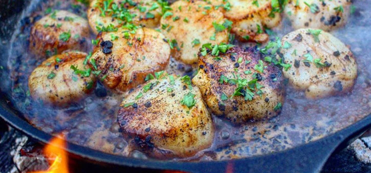 smoked beer glazed scallops in cast iron pan over live fire