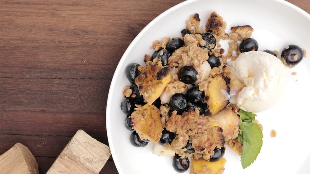 blueberry peach crumble with ice cream in a bowl