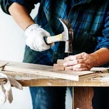 Picture of a handyman nailing blocks of wood together for home installations.