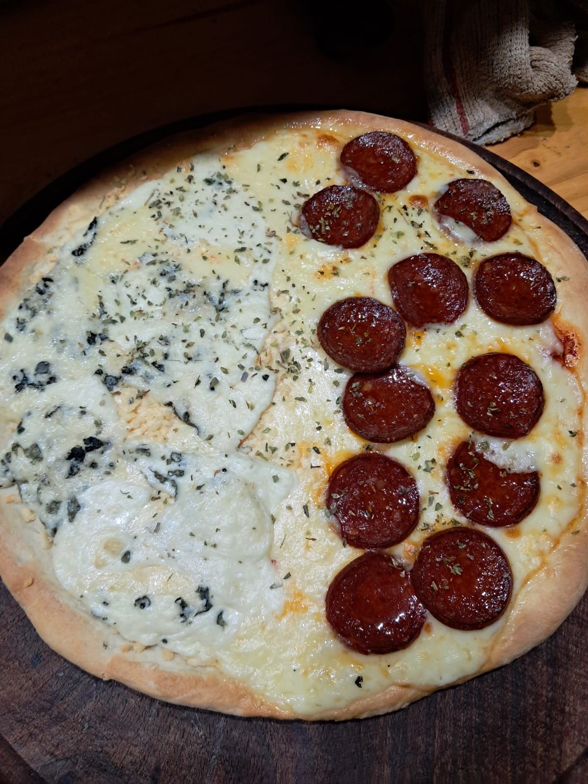 Pizza mitad queso, mitad pepperoni en una bandeja para hornear