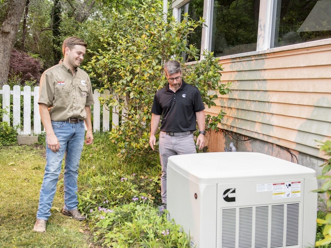 Air conditioning units with toolbox and gloves in backyard.
