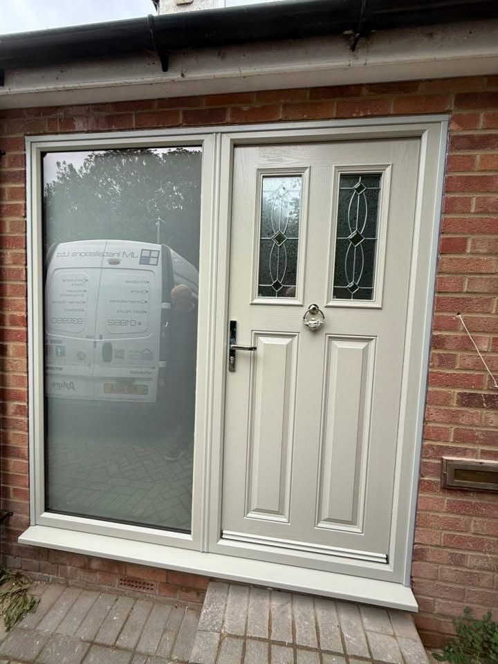 Exterior door with sidelight, light gray frame, brick exterior, and a glimpse of a van.