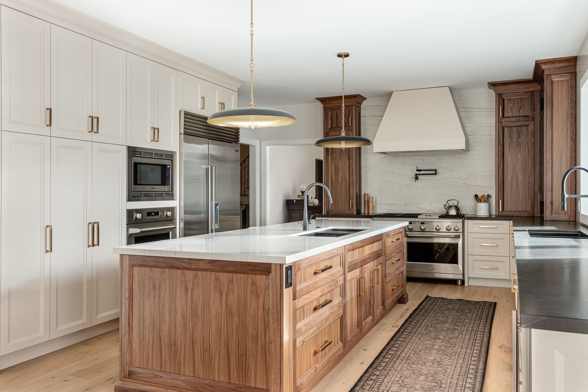 Bright modern kitchen with white cabinets, wood island, and stainless steel appliances