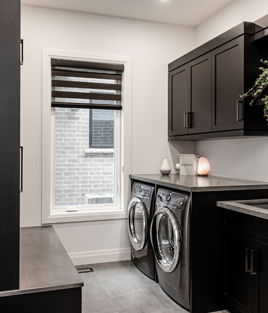 A laundry room with a washer and dryer and a window.