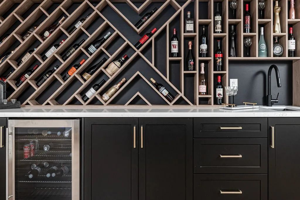 Modern kitchen bar with black cabinets, wine rack wall, and built-in glass-front beverage fridge