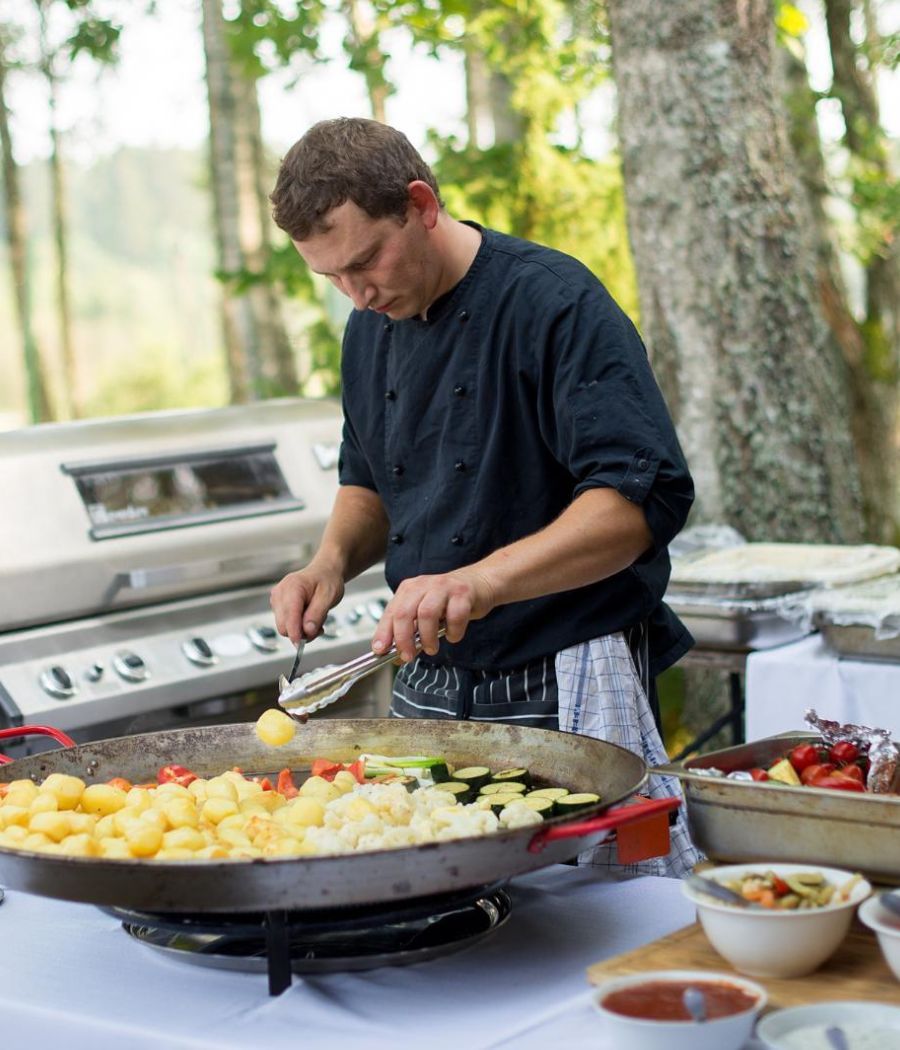 person cooking on grill outdoor kitchen