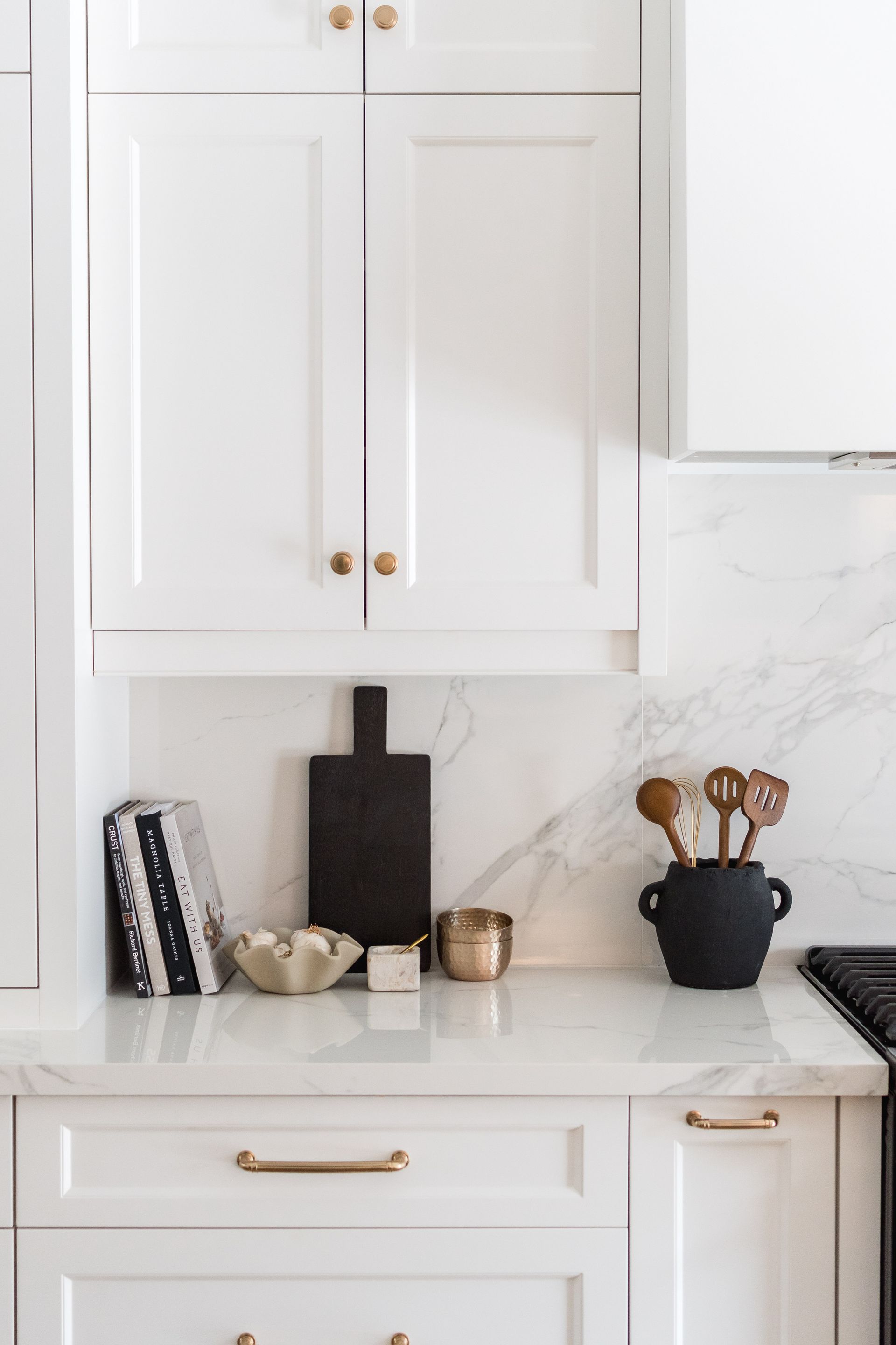 A kitchen with white cabinets and a black stove top oven.