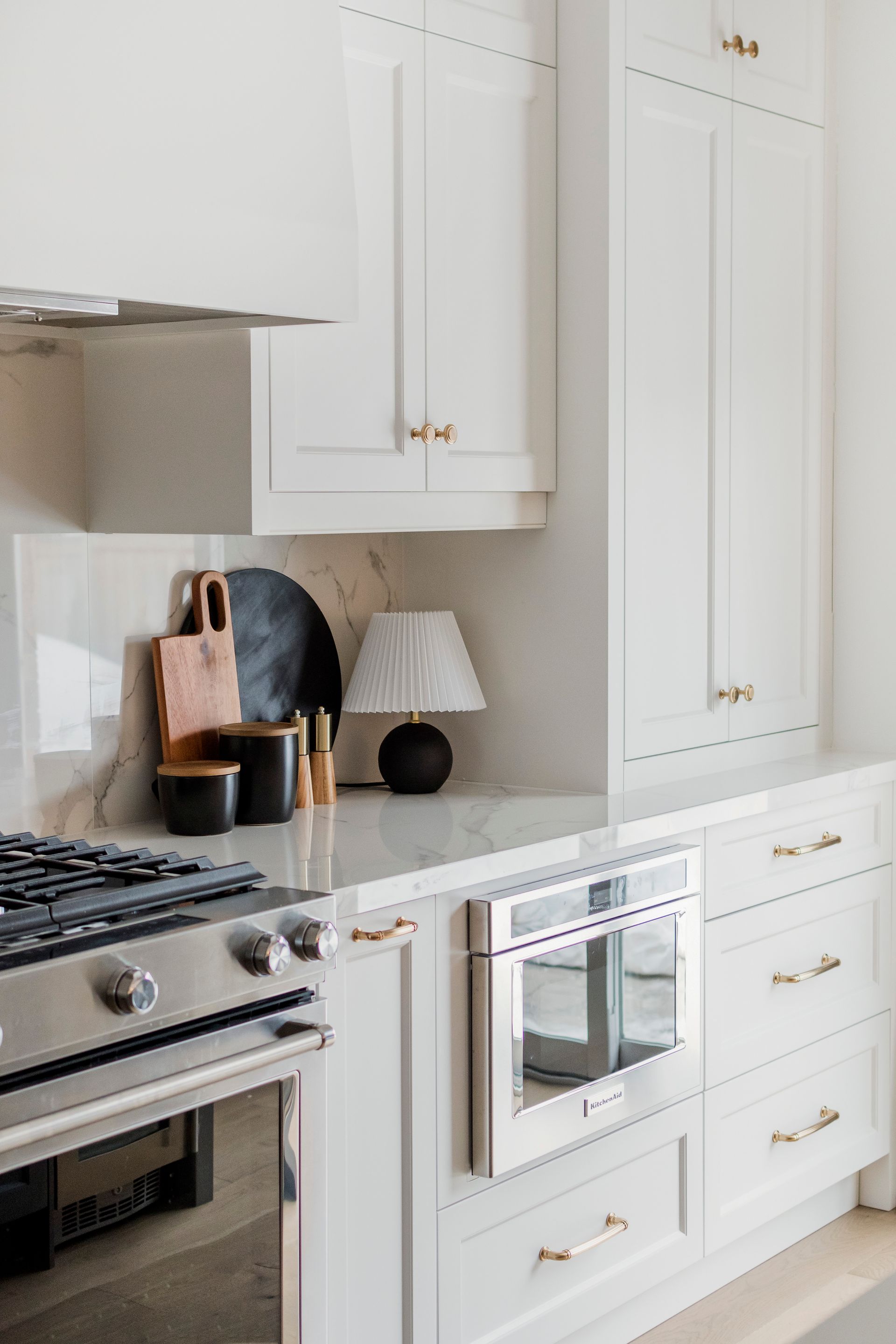 A kitchen with white cabinets , stainless steel appliances , and a stove.