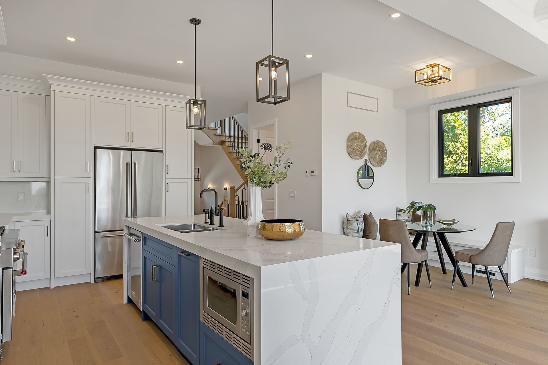A kitchen with a large island in the middle and a dining room in the background.