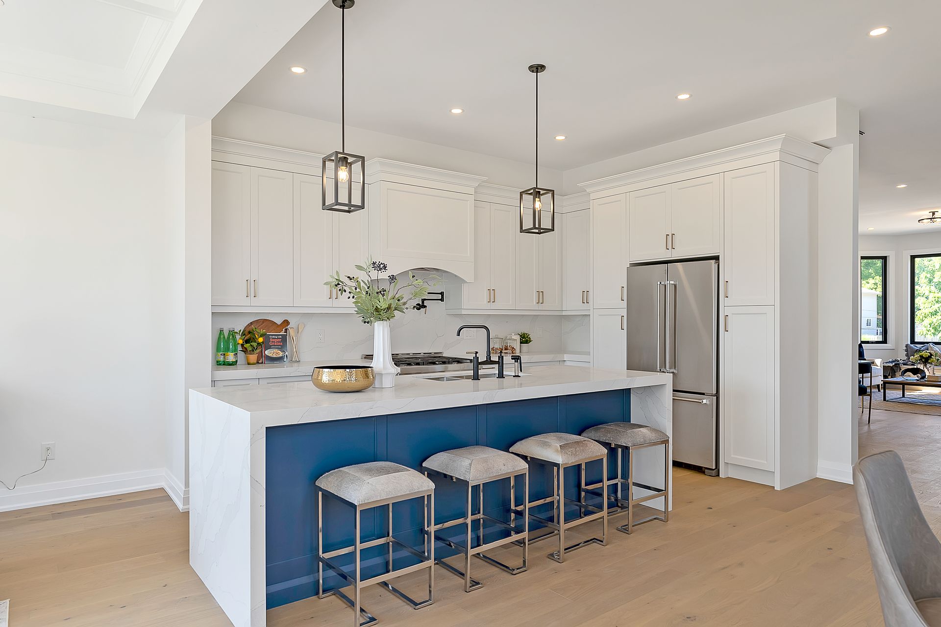 A kitchen with white cabinets and blue counter tops and stools.