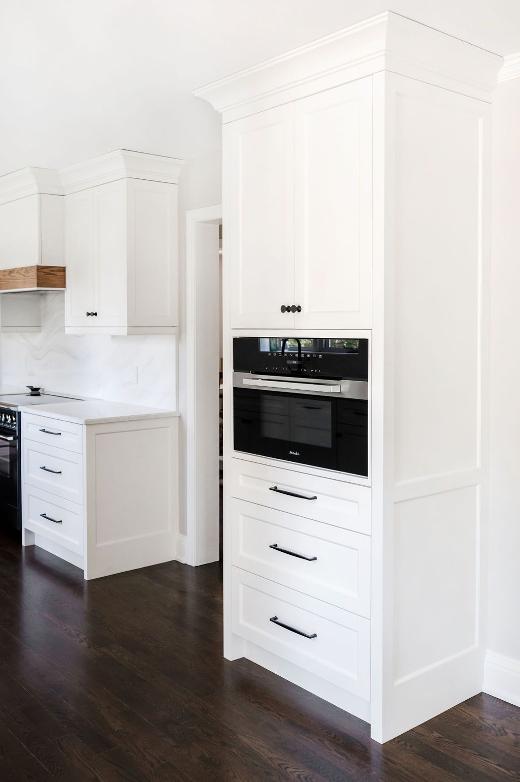 A kitchen with white cabinets and a microwave oven.