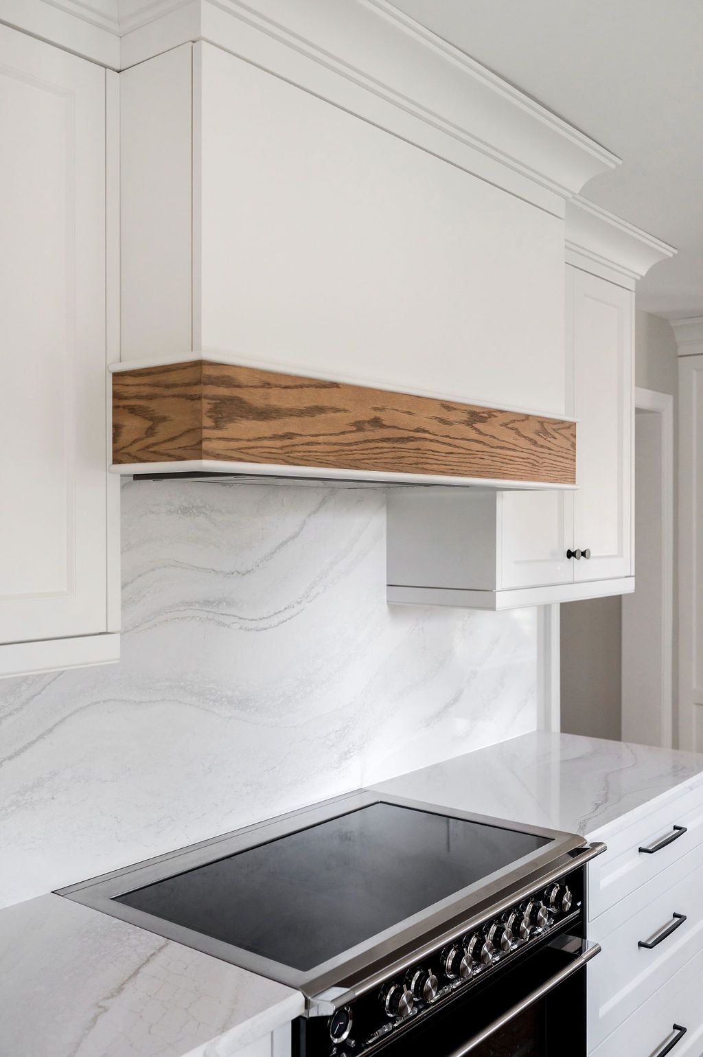 A kitchen with white cabinets and a stove top oven