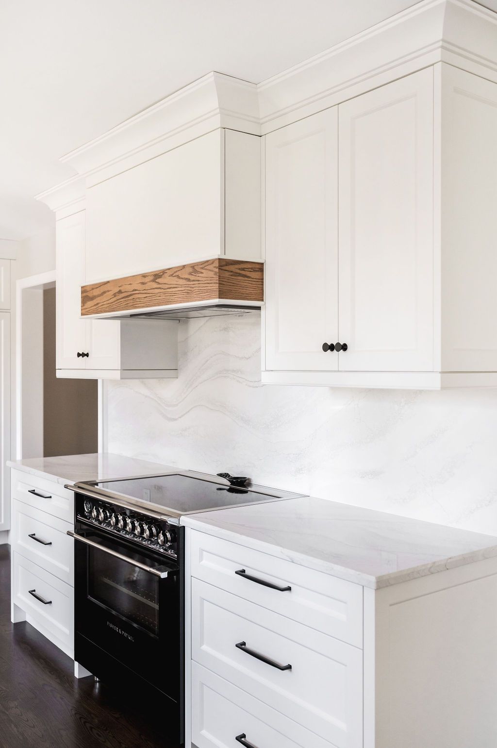 A kitchen with white cabinets and a black stove top oven