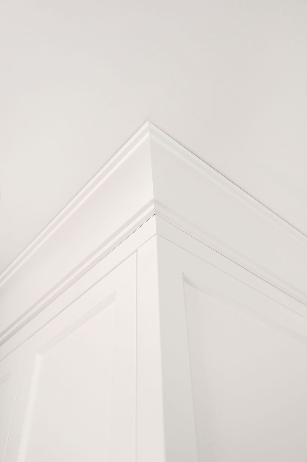 A close up of a white molding on the corner of a cabinet.